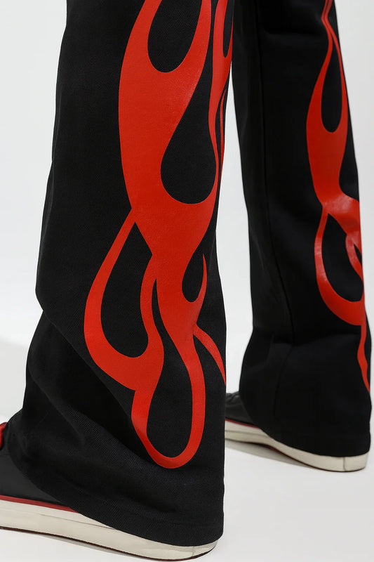 Black streetwear pants with bold red flame print and sneakers