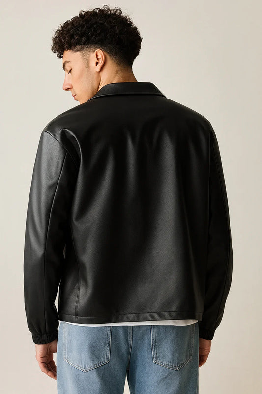 Man in black faux leather jacket with collar, light blue jeans, back view, urban style