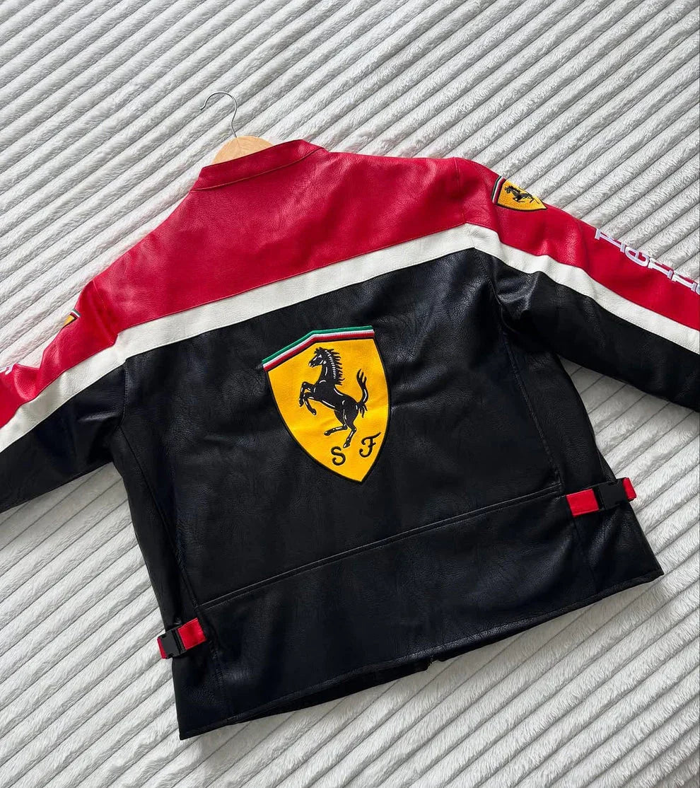 Black and red leather jacket with large yellow prancing horse crest on the back, laid flat on bed